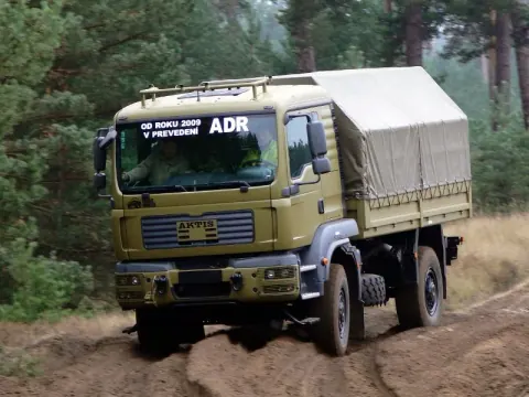 Camion de la maison mère, plateau bâché, roulant sur une piste forestière
