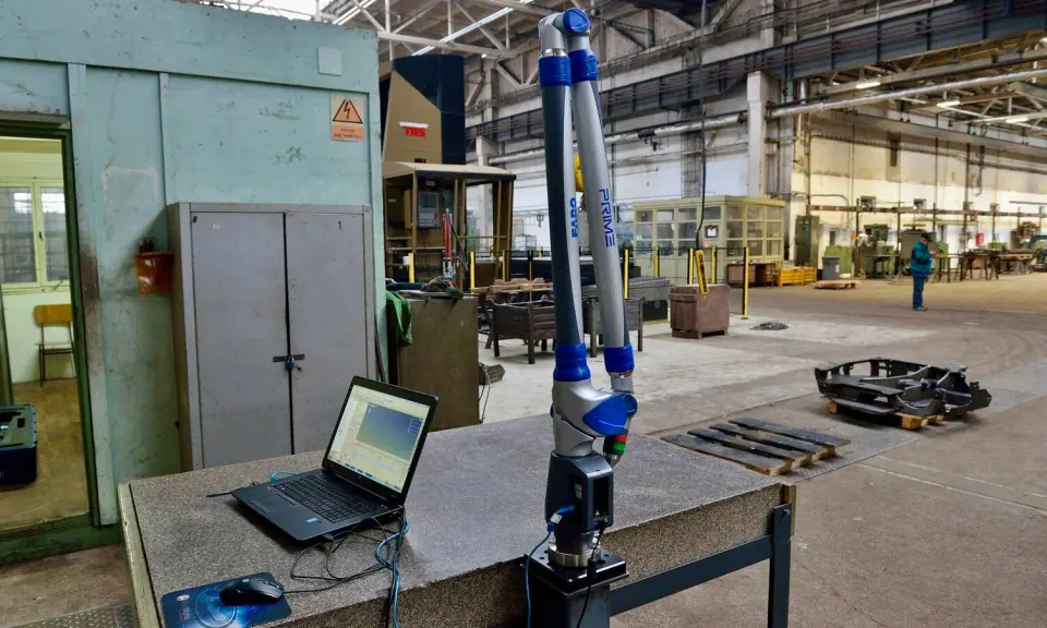 Bras de mesure portable fixé sur une table en granit, avec l'ordinateur portable qui enregistre ses mesures